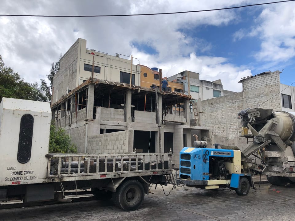 Bomba estacionaria y mixer de hormigón durante la fundición de una estructura de tres plantas