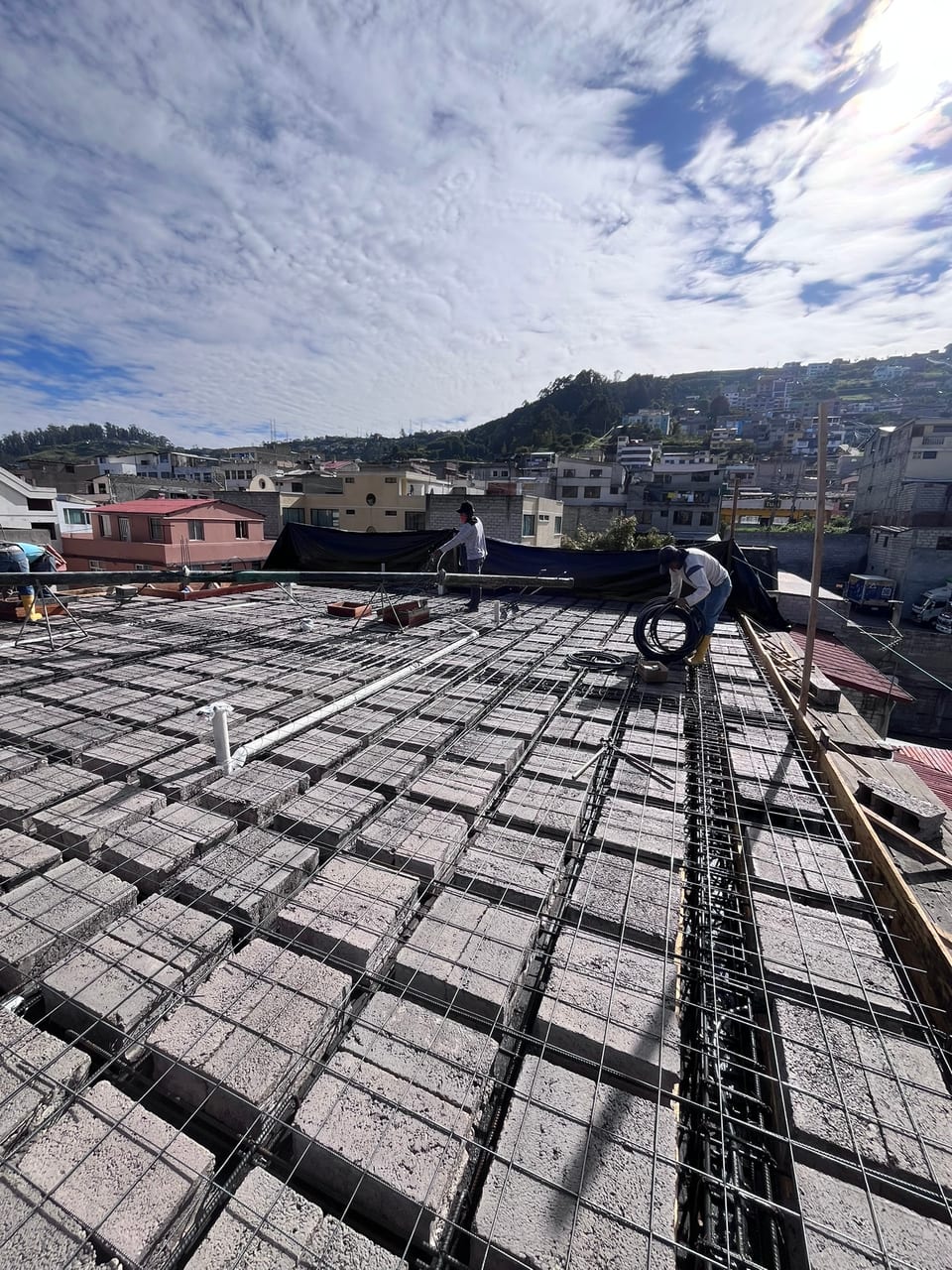 Losa alivianada armada con bloque y acero de refuerzo, con la ciudad de Quito al fondo